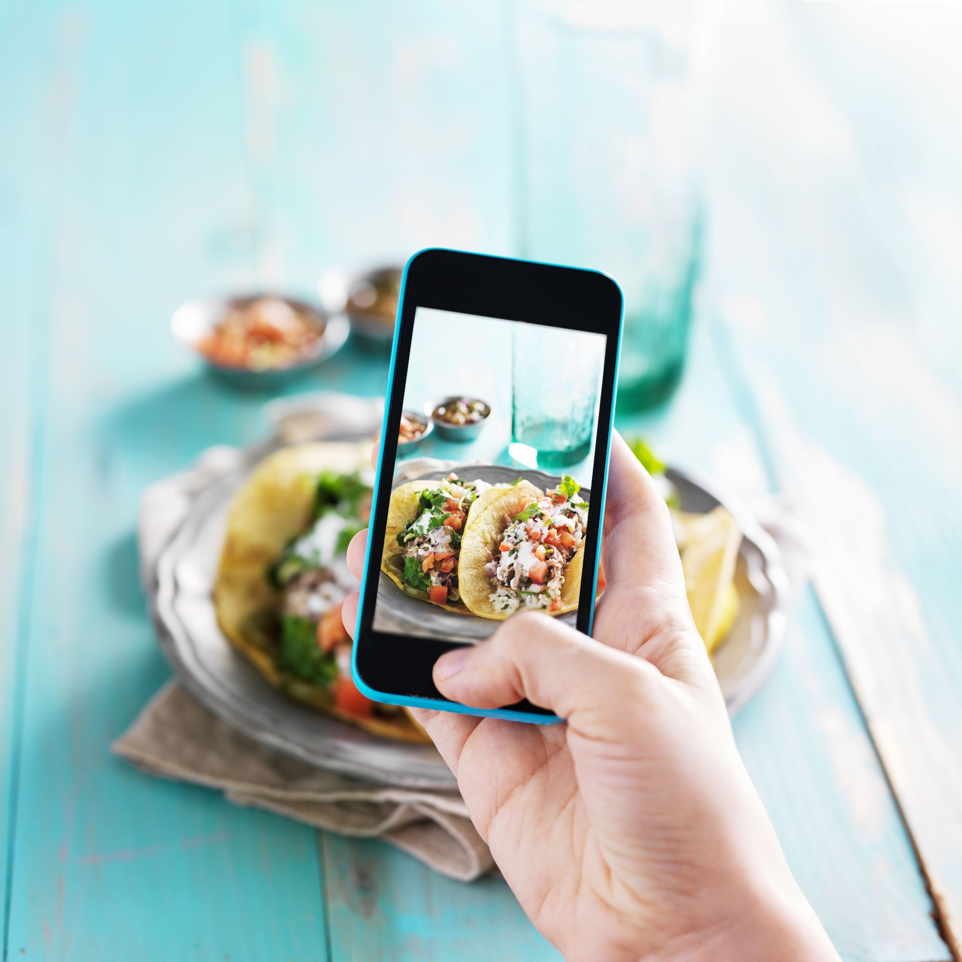 taking photo of carnitas street tacos with smart phone